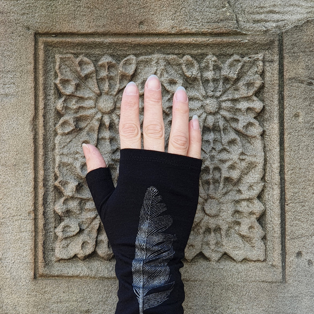 Women’s black winter fine merinp wool fingerless mittens, in a angel wing bird feather print, perfect for cold weather. Dunedin made evening arm warmers.